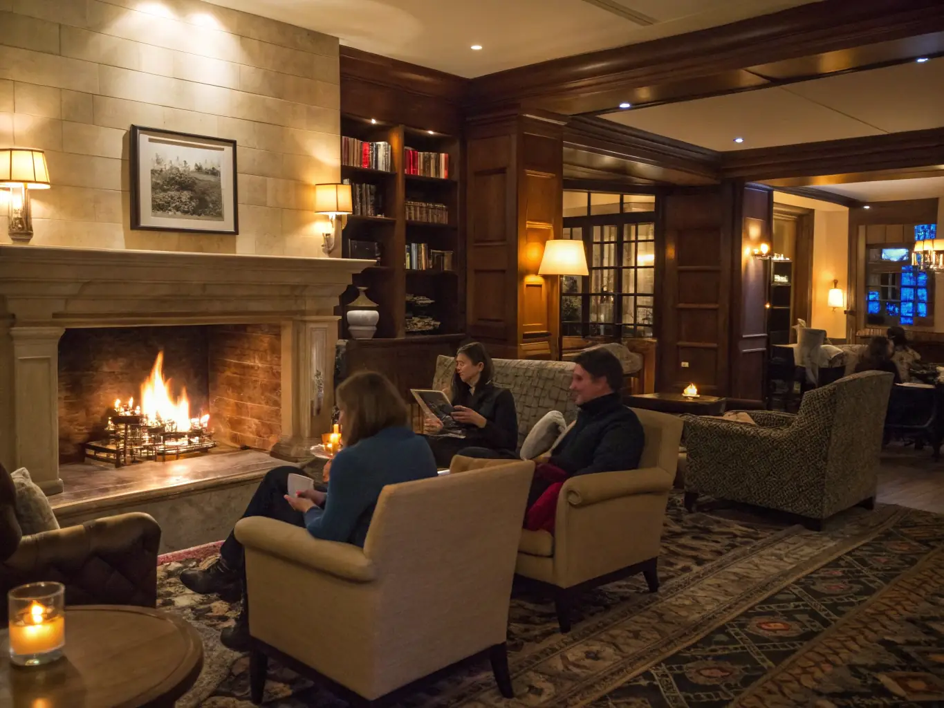 An elegant resident lounge with comfortable seating, a fireplace, and a coffee bar. Residents are socializing, working on laptops, and enjoying the relaxed ambiance.